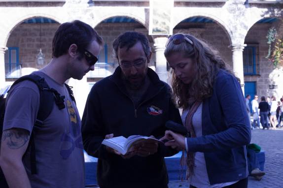 Com o Rafa, buscando informações no livro durante passeio pelo centro de Havana - Cuba (foto de Laura Schunemann)